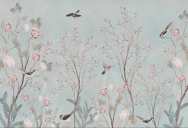 Papel tapiz con diseño botánico de árboles, peonías rosadas y pájaros volando sobre fondo verde menta suave.