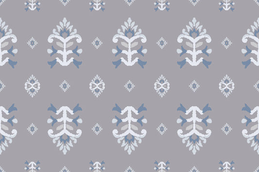 Papel tapiz con patrón ikat floral y medallones étnicos en tonos gris lavanda, blanco y azul suave.